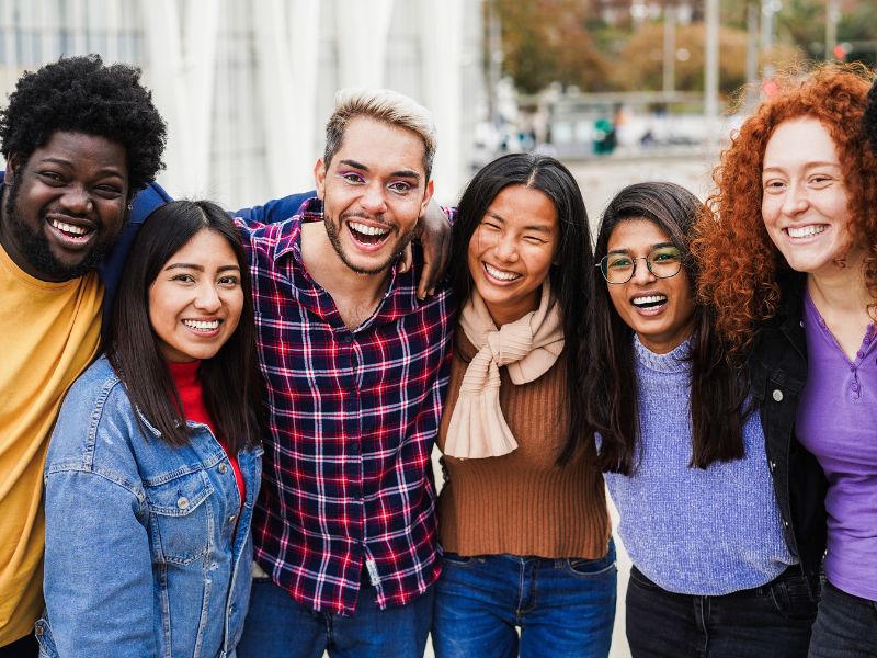 Young multiracial people having fun outdoor laughing together - Diversity and lifestyle concept during fall season